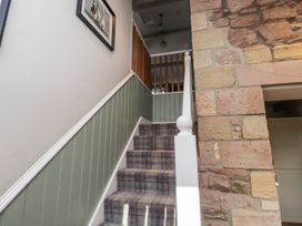 A staircase with carpet and stone wall at Millstone in Lucker