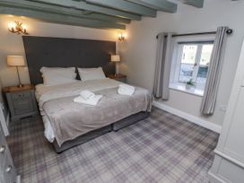 A bedroom with a bed and bedside tables at Millstone in Lucker