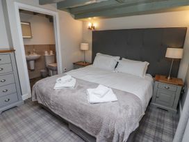 A bedroom with a bed and en-suite bathroom at Millstone in Lucker