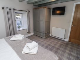 A bedroom with a bed and cabinet at Millstone in Lucker