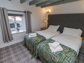 A bedroom with twin beds and a window at Millstone in Lucker