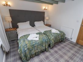 A bedroom with two beds and nightstand at Millstone in Lucker
