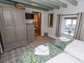 A bedroom with two beds and a wardrobe at Millstone in Lucker