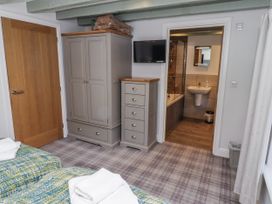 A bedroom with two beds and storage furniture at Millstone in Lucker