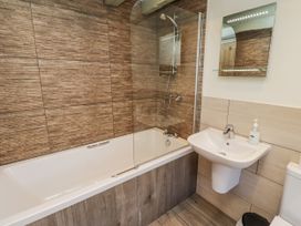 A bathroom with a bathtub, toilet, and sink at Millstone in Lucker