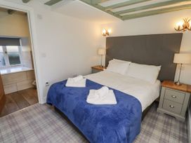 A bedroom with a bed and bedside tables at Millstone in Lucker