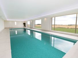 An indoor pool with large windows at Nook Cottage in Embleton