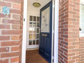 An entrance with a blue door and brick wall at 6 Westview in Embleton