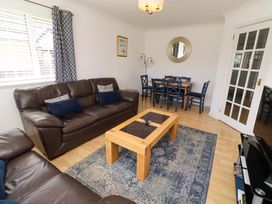 A living room with a sofa and dining table at 6 Westview in Embleton