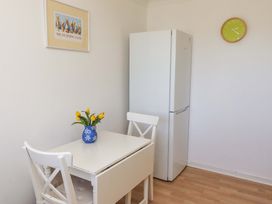 A kitchen with a table and chairs and a refrigerator at 6 Westview Embleton