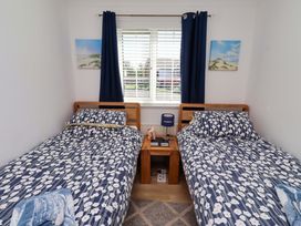 A bedroom with two beds and a bedside table at 6 Westview Embleton