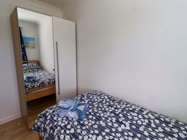 A bedroom with two beds and a wardrobe at 6 Westview Embleton