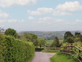 A view of a road bordered by hedges and trees at Palace Farmhouse in St Weonards