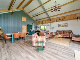 A living room with furniture and kitchen area at Bwncath Garthmyl