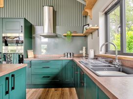 A kitchen with cabinets and a sink at Bwncath in Garthmyl