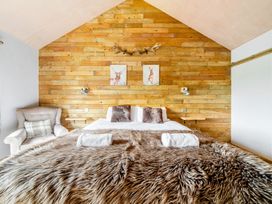 A bedroom with a bed and armchair at Bwncath in Garthmyl