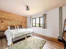 A bedroom with a bed and window at Bwncath in Garthmyl