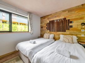 A bedroom with twin beds and a window at Bwncath Garthmyl