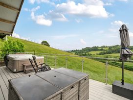An outdoor area with a hot tub and seating at Bwncath in Garthmyl