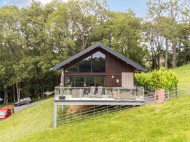 A house with a deck and hot tub at Bwncath in Garthmyl