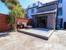 A garden with decking and seating area at Ty Haul Rhosneigr