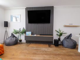 A living room with a television and bean bag chairs at Ty Haul in Rhosneigr