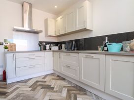 A kitchen with cabinets and appliances at Ty Haul in Rhosneigr