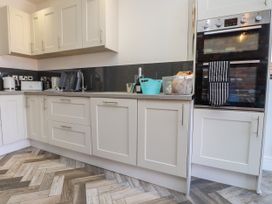 A kitchen with cabinets, countertop and oven at Ty Haul, Rhosneigr