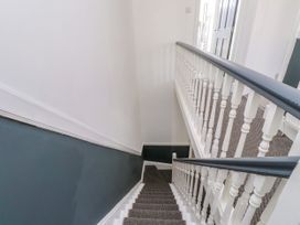 A staircase with a handrail and carpet at Ty Haul in Rhosneigr