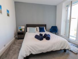 A bedroom with a bed and towels at Ty Haul in Rhosneigr