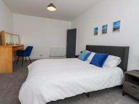 A bedroom with a bed and desk at Ty Haul in Rhosneigr