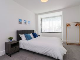 A bedroom with a bed and nightstand at Ty Haul in Rhosneigr