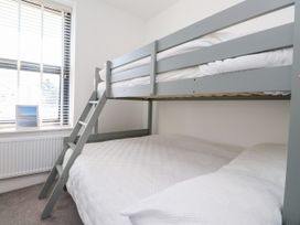 A bedroom with a bunk bed and a window at Ty Haul in Rhosneigr