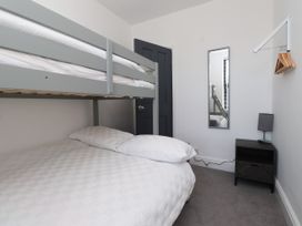 A bedroom with a bunk bed and double bed at Ty Haul in Rhosneigr