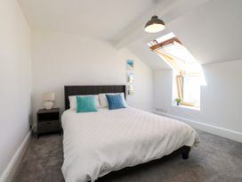 A bedroom with a bed and window at Ty Haul in Rhosneigr