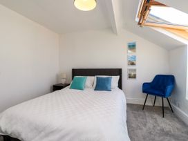 A bedroom with a bed and nightstand at Ty Haul in Rhosneigr