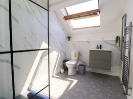A bathroom with a shower, toilet, sink and skylight at Ty Haul in Rhosneigr