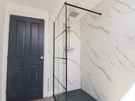 A bathroom featuring a shower and a door at Ty Haul in Rhosneigr