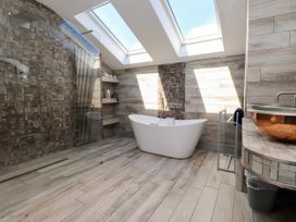 A bathroom with a shower and bathtub at Ty Haul in Rhosneigr