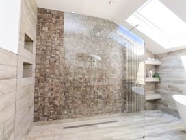 A bathroom with a shower and bathtub at Ty Haul in Rhosneigr