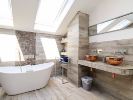 A bathroom with a bath tub and two sinks at Ty Haul in Rhosneigr