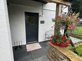 A door with a doormat and flowers at How Hill Farm Cottage in Greystoke