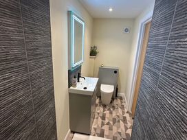 A bathroom with a sink, toilet and mirror at How Hill Farm Cottage in Greystoke