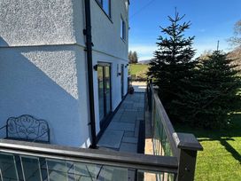An outdoor area with a patio and glass doors at How Hill Farm Cottage in Greystoke