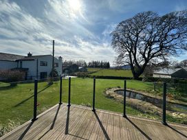 An outdoor area with a deck and garden at How Hill Farm Cottage in Greystoke