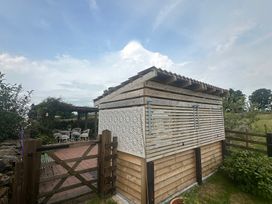A wooden shed with decorative panels in a garden at How Hill Farm Cottage Greystoke