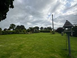 A garden with grass and trees at How Hill Farm Cottage Greystoke