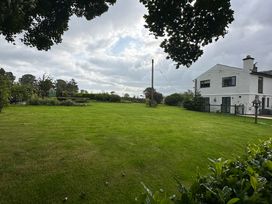 A garden with grass and trees at How Hill Farm Cottage in Greystoke