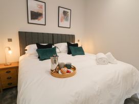 A bedroom with a bed with white bedding pillows and a breakfast tray at Bracken Cottage in Pocklington
