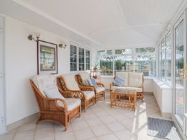 A conservatory with seating and a table at Rainbow View in Churchstanton near Churchinford